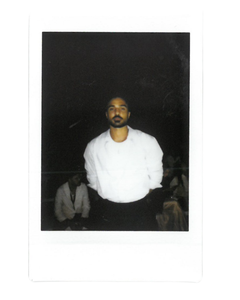 Ahmad Blaibleh in a white shirt and blue over shirt poses 