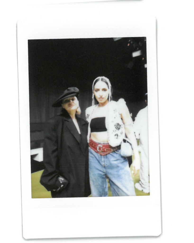 angelina root poses in a wide brimmed hat and blazer
